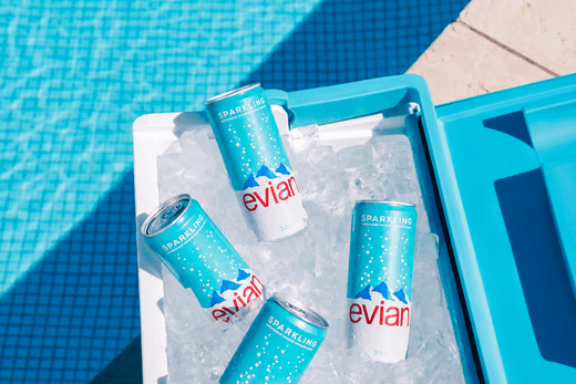Canettes Evian pétillante 33 cl sur glace au bord d'une piscine
